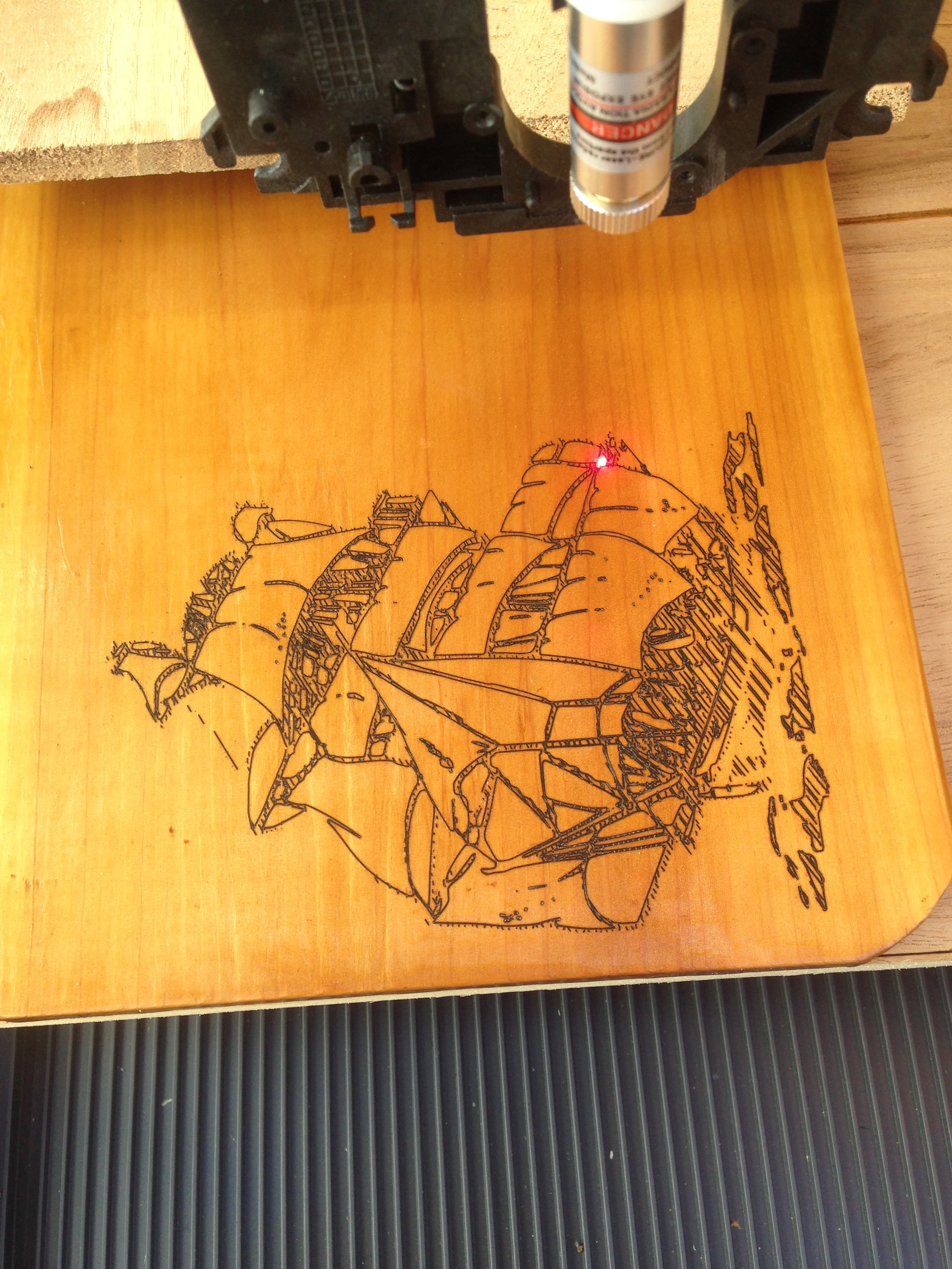 A ship being engraved into a piece of balsa wood.